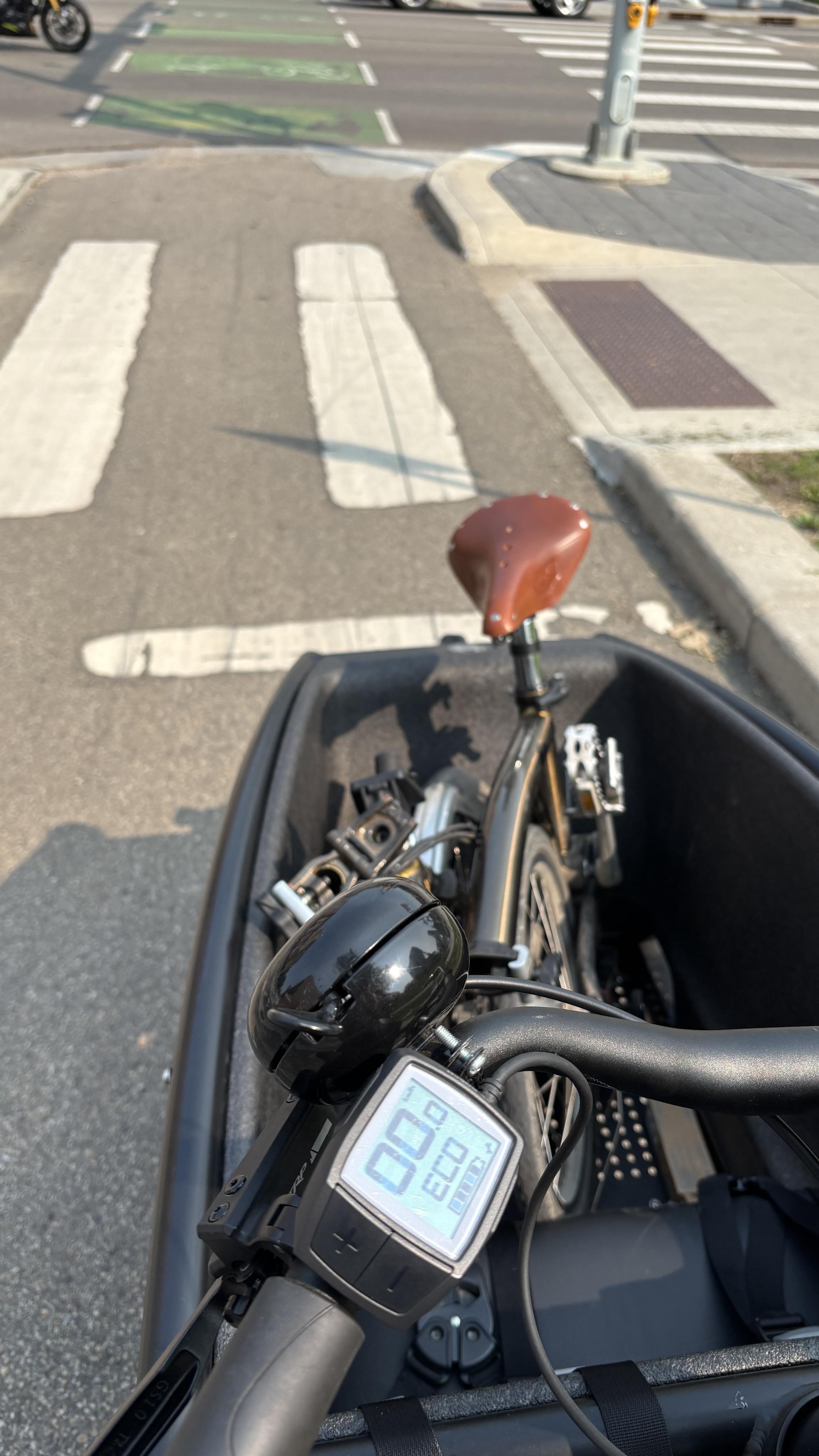 Folded Brompton bike in the front of a bakfiets